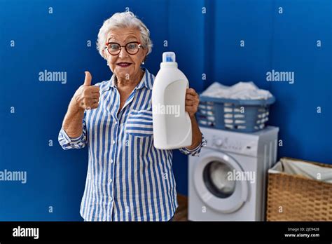 Senior Woman With Grey Hair Holding Detergent Bottle Smiling Happy And