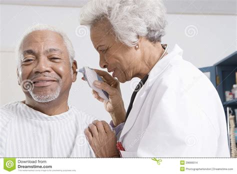 Orelha Do Doutor Checking Patient Usando O Otoscope Eletrônico Foto De