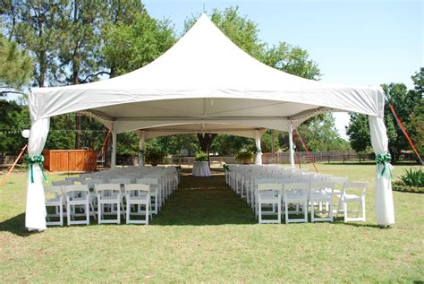 Event Tent Set Up With White Garden Chairs For Outdoor Wedding Ceremony