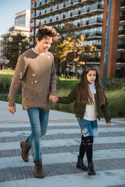 Hombre Feliz Con Su Hija Caminando Juntos En El Pavimento Foto Gratis