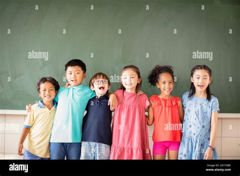 Multi Ethnic Group Of School Children Standing In Classroom Stock Photo