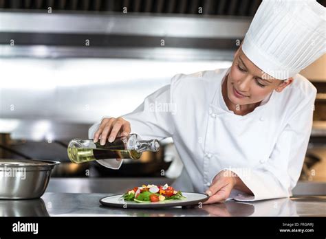Female Chef Pouring Oil On Food In Plate Stock Photo Alamy