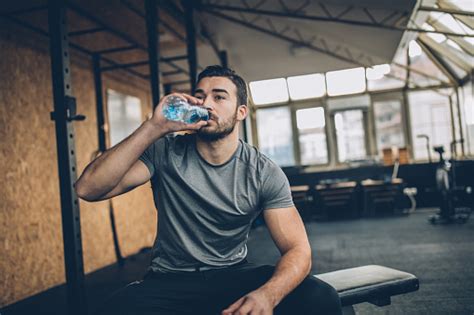 Man Drinking Water After Training In Gym Stock Photo