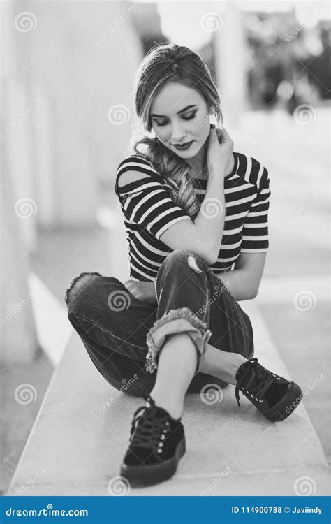 Blonde Woman Model Of Fashion Sitting In Urban Background Stock