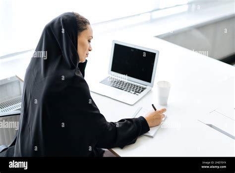beautiful woman with abaya dress working on her computer middle aged female employee at work in