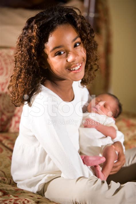 African American Child Holding Tiny Newborn Baby Stock Photos