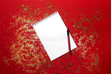 Notepad And Pen On A Red Background With Shiny Particles Stock Photo