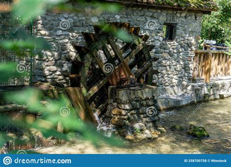Beautiful Vintage Wooden Water Mill Near A Stone House Stock Photo