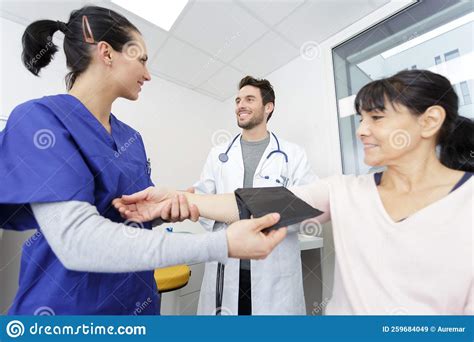 Caring Medical Doctor Taking Mid Age Womans Blood Pressure Stock Image