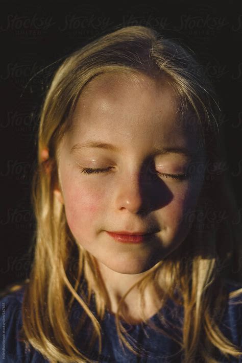 A Little Girl Enjoying Sunshine With Her Eyes Closed By Stocksy