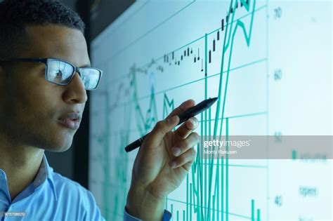 Businessman Studying Graphs On An Interactive Screen In Business