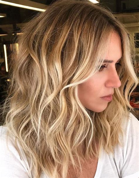 The long bangs and subtle highlights over dark brown hair add to the charm of this cute haircut. Blonde Hairstyles Trend for Young Girls In 2019 | PrimeMod