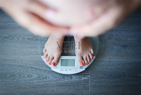 一名孕妇在浴室磅秤上称体重照片摄影图片 ID 132321042 Veer图库
