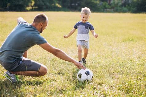 Padre Con Hijo Jugando Al Fútbol En El Campo Foto Gratis