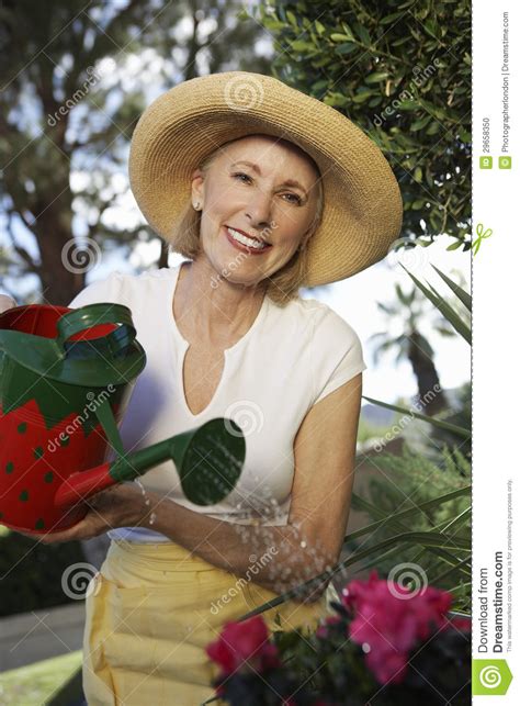 Senior Woman Watering Plants Stock Photo Image Of Adult Outdoors
