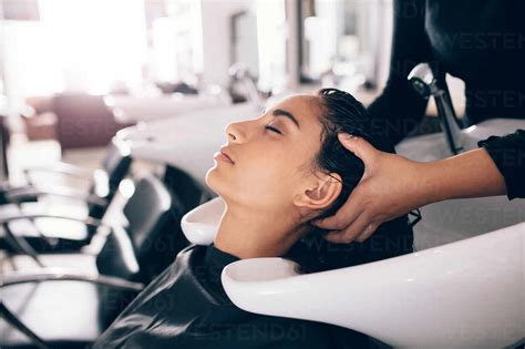 Female Hairdresser Rinsing Hair Of A Customer Woman Getting Hair Spa