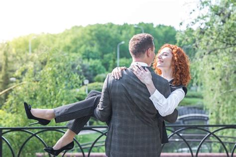 Premium Photo The Husband Is Holding His Wife In His Arms Redhead