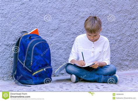 Boy Doing School Homework Kid Reading Writing And Thinking Sitting On