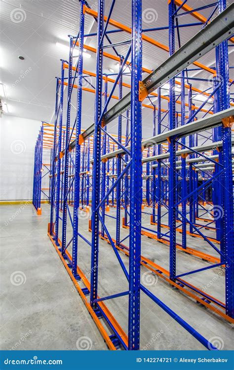Blue And Orange Metal Shelves For Storing Goods In A Large Warehouse