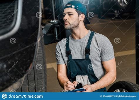 Young Repairman With Notepad Checking Car Wheels Stock Image Image Of