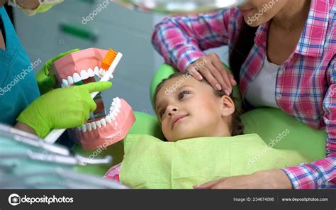 Friendly Pediatric Dentist Explaining Child How Brush Teeth Properly