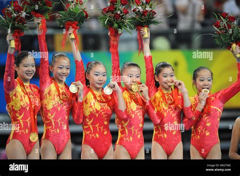 The Chinese Womens Gymnastics Team Shows Their Gold Medals On The Awards Podium For The Womens
