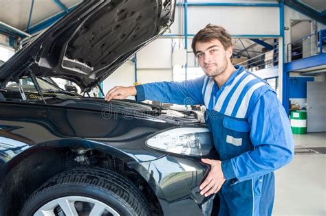 Mechanic Repairing Car On Hydraulic Lift In Automobile Shop Stock Image