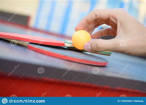 Male Hand Holds Ping Pong Ball On Small Tennis Table In