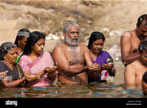 hindú hombres y mujeres bañándose y rezando en el río ganges por kshameshwar ghat en la santa