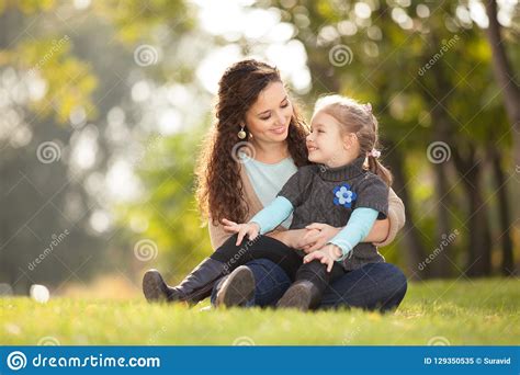 Mother And Daughter Walking In The Autumn Park Stock