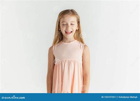 Little Smiling Girl Posing In Dress On White Studio Background Stock