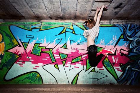 Stylish Girl In A Dance Pose Against Graffiti Wall Editorial Photo