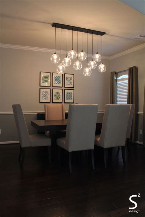 Dining Room With Modern Light Fixture Neutral Colors With Pops Of Green