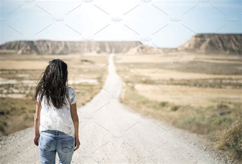 Woman Walking On Dirt Road Stock Photo Containing Road And Dirt