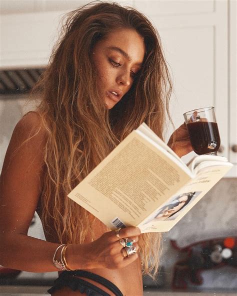 A Woman Reading A Book While Holding A Glass Of Wine