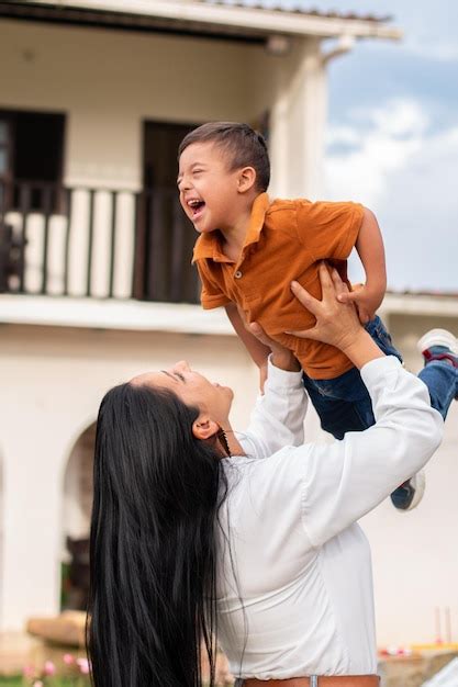 Una Madre Alegre Levanta A Su Hijo Con Síndrome De Down Y Comparte Una