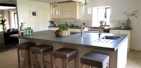 Large kitchen island with sink and hob. Dark Grey concrete island with sink, drainer grooves and ...