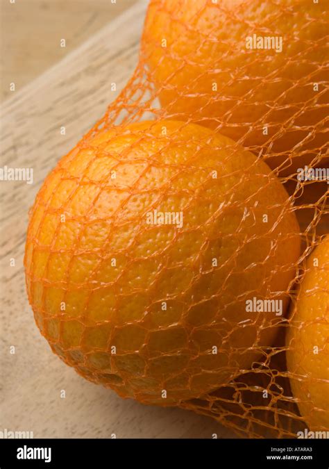 Oranges In Net Bag On Wooden Chopping Board Stock Photo Alamy