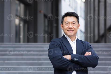 Portrait Of Asian Cheerful And Successful Businessman Near Office In