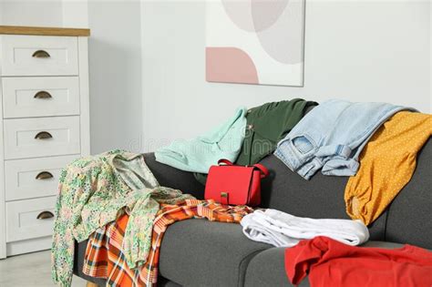 Messy Pile Of Clothes On Sofa In Living Room Stock Photo Image Of