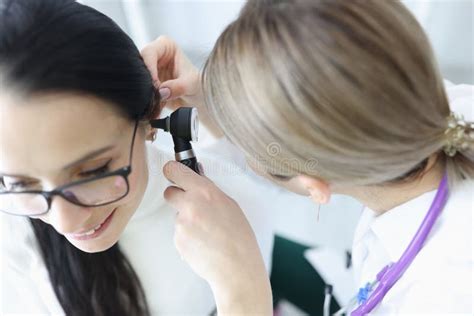 Otorhinolaryngologist Doctor Examining Patients Ear With Otoscope In