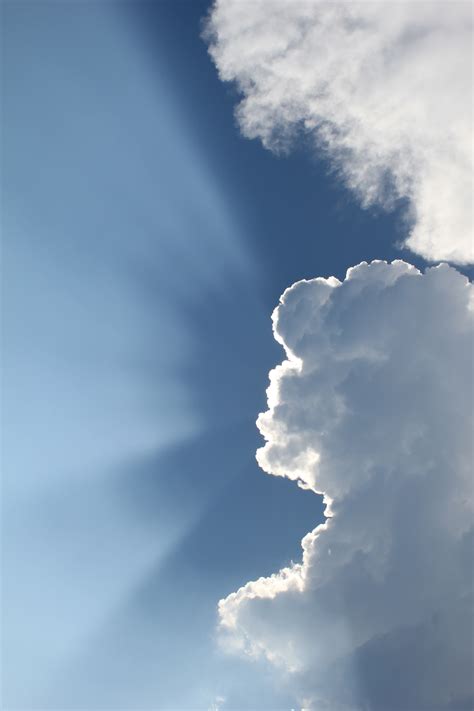 Sun Shining Behind Clouds In Blue Sky · Free Stock Photo