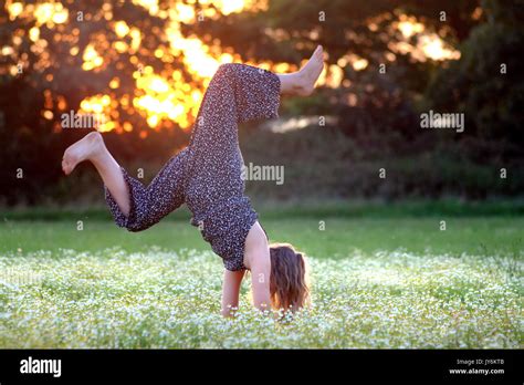 Young Girldoing Handstands In A Meadow Of Flowers Stock Photo Alamy