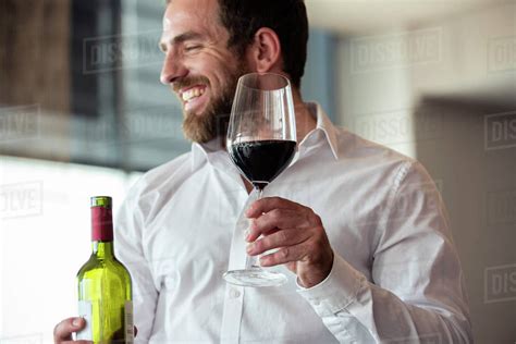 Mid Adult Man Holding Wine Bottle And Glass Stock Photo Dissolve