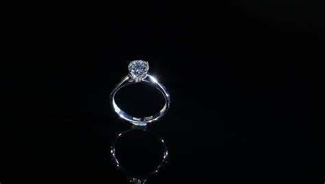 Expensive Silver Diamond Ring Turning On Themselves Against A Black