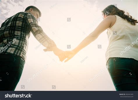 Romantic Couple Clasped Hands Backlit By Stock Photo 492441445