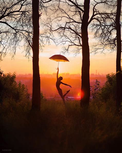 A Person Jumping In The Air While Holding An Umbrella Over Their Head