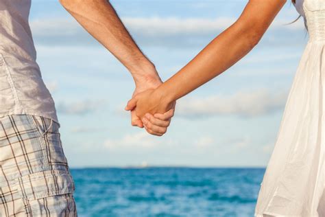 Romantic Couple Holding Hands On Beach Sunset During Travel Happy