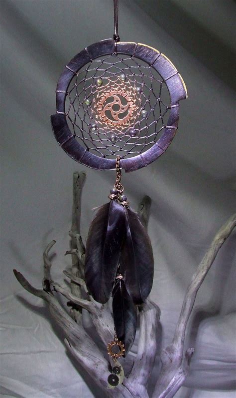 A Purple Dream Catcher Hanging From A Tree Branch