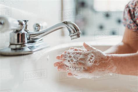 Close Up View Of Young Child Washing Hands With Soap In Sink Stock